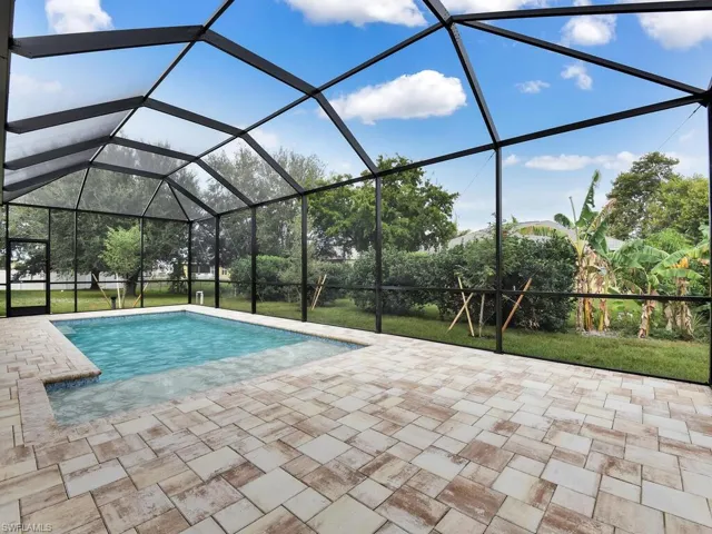Outdoor pool with a sunroom and a lanai
