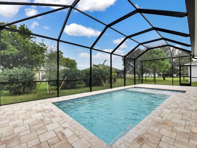 Outdoor pool with a sunroom, a yard, a lanai, and a patio area