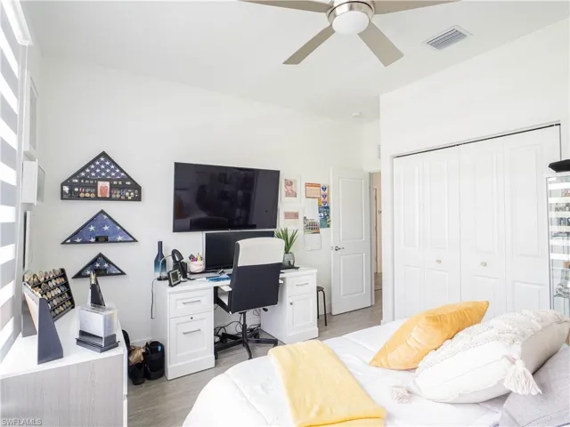 Bedroom featuring light wood-type flooring, ceiling fan, and a closet
