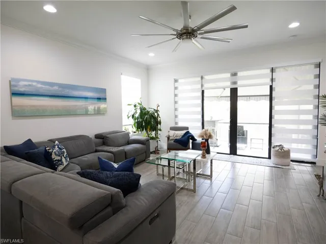 Living room featuring ornamental molding, light hardwood / wood-style floors, and ceiling fan