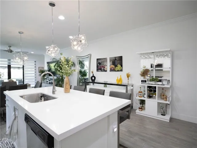 Kitchen featuring white cabinetry, an island with sink, stainless steel appliances, hardwood / wood-style floors, and sink