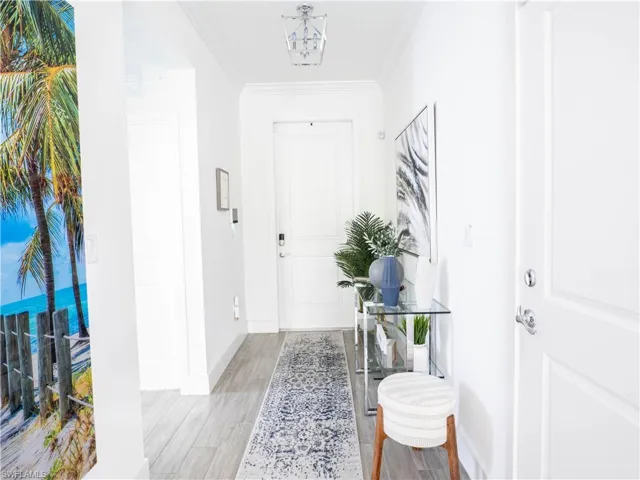 Foyer featuring ornamental molding and light wood-type flooring