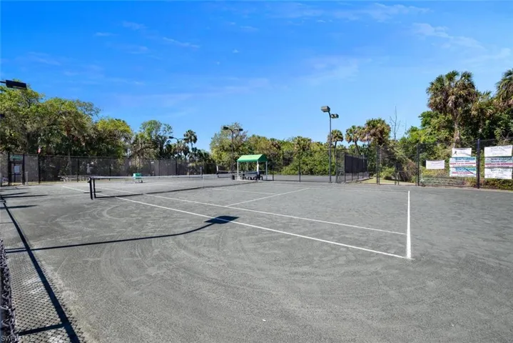 View of tennis court featuring fence