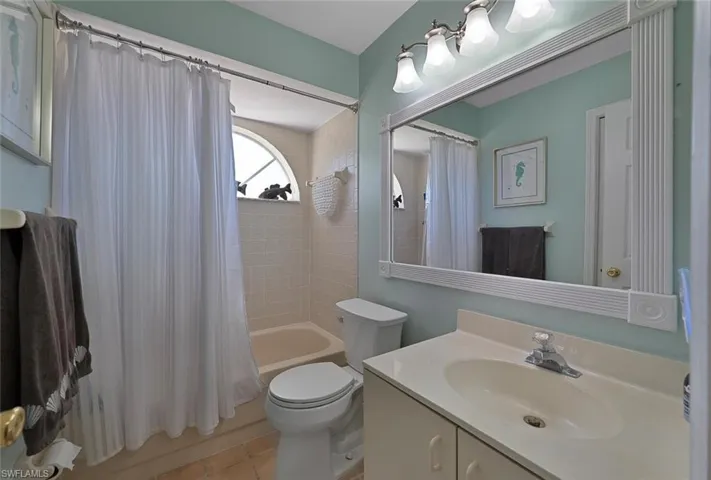 Full bathroom with vanity, toilet, tile patterned flooring, and shower / bath combination with curtain