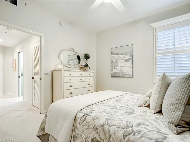 Bedroom featuring a large closet, ceiling fan, and light carpet