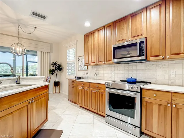 Another view of the kitchen with newer stove and microwave