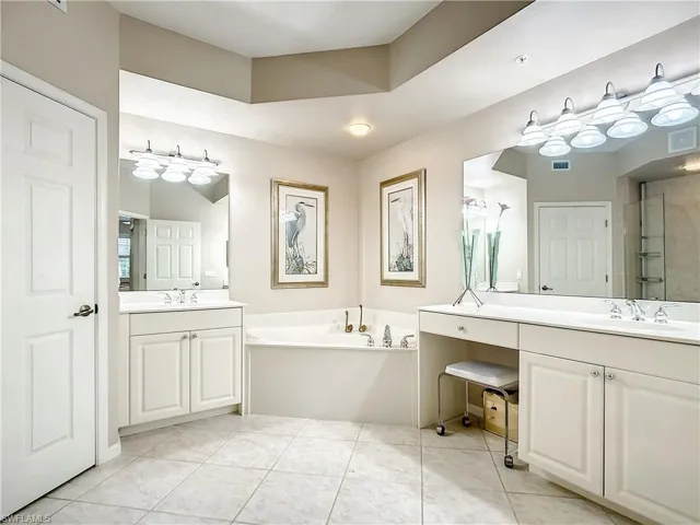 Bathroom with a tub, two separate vanities, soaking tub and separate water closet.