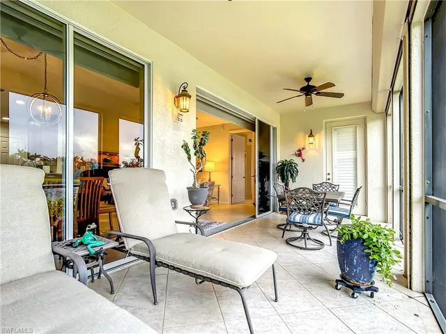 Screened lanai with electric hurricane shutters and two ceiling fans overlooking the water.