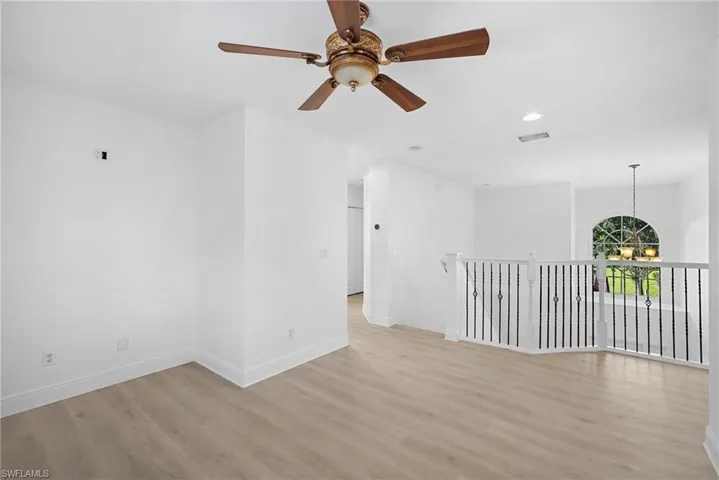 Stairs landing featuring recessed lighting, a chandelier, light wood-style floors, and a ceiling fan
