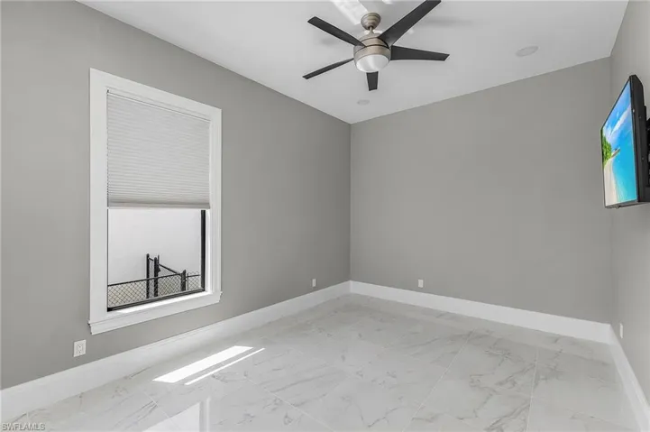 Empty room with a wealth of natural light and ceiling fan