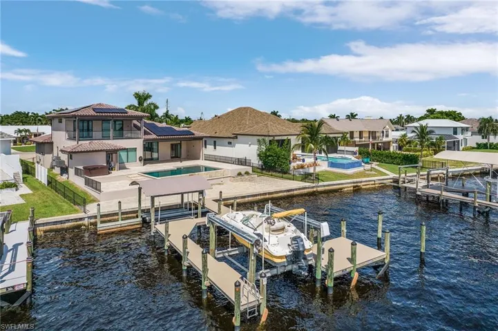 View of dock with a balcony, a patio area, and a water view