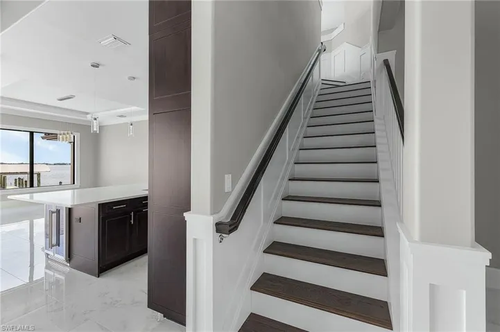 Stairway featuring wine cooler and a tray ceiling