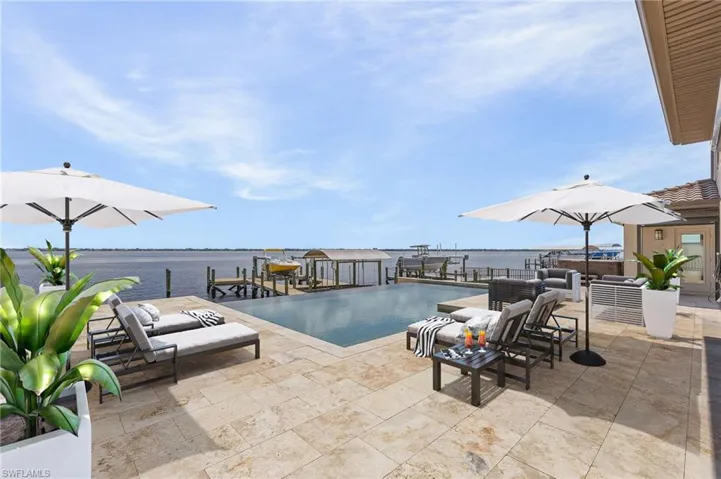 View of pool featuring an outdoor living space, a patio area, and a water view