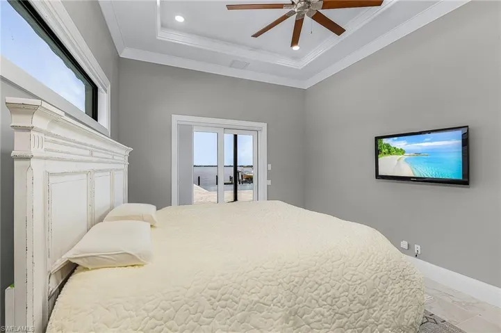 Bedroom featuring crown molding, ceiling fan, a tray ceiling, and access to outside