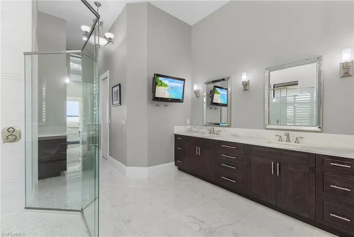 Bathroom featuring a shower with door, a chandelier, and vanity
