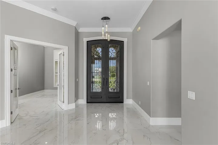 Foyer entrance featuring ornamental molding and french doors