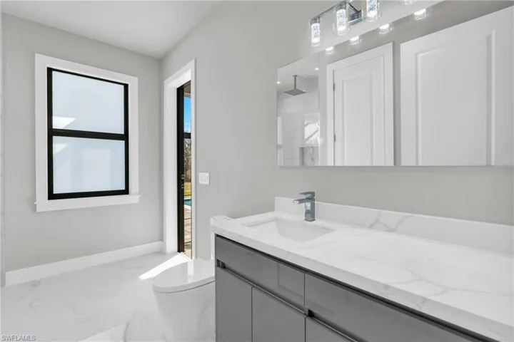 Bathroom with vanity, plenty of natural light, a shower, and toilet