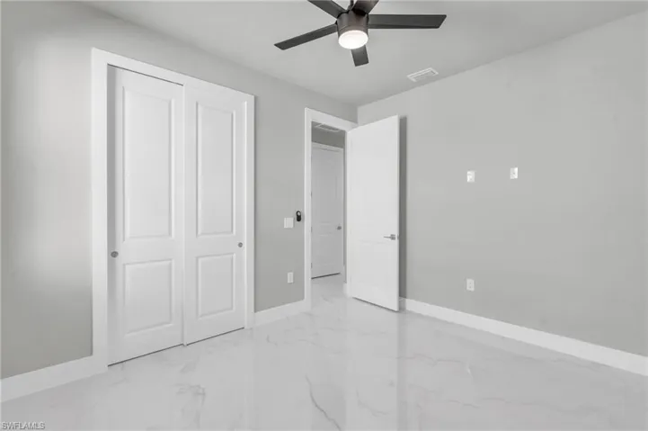 Unfurnished bedroom with ceiling fan and a closet