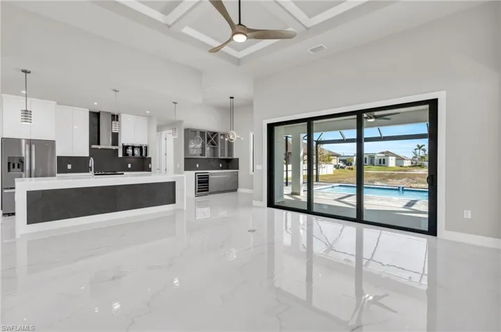 Unfurnished living room with ceiling fan and coffered ceiling
