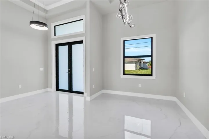 Entrance foyer featuring a high ceiling, a wealth of natural light, a chandelier, and french doors