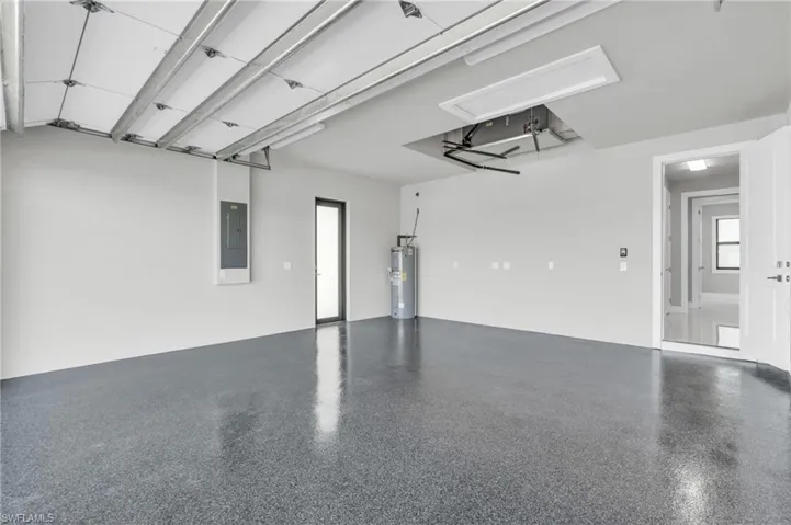 Garage featuring electric panel and water heater