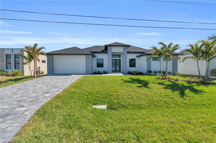 View of front of home featuring a garage and a front lawn