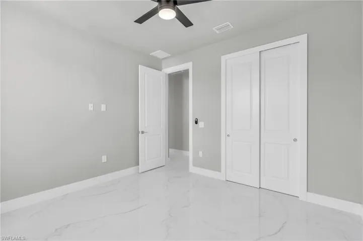 Unfurnished bedroom featuring ceiling fan and a closet