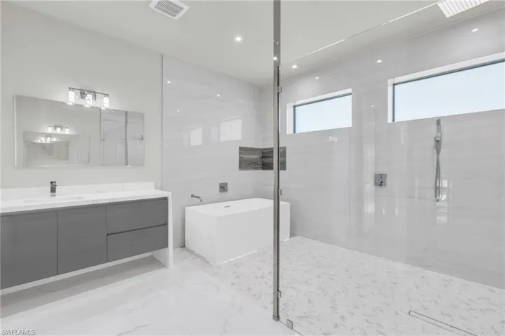 Bathroom featuring vanity and shower with separate bathtub