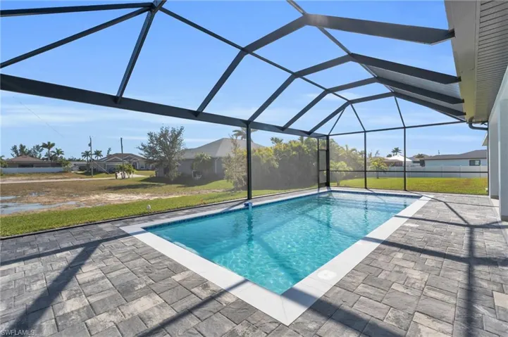 View of pool featuring a lanai, a patio area, and a lawn