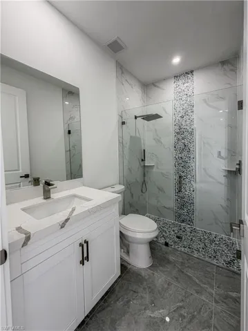 Bathroom featuring a glass-enclosed shower with wall-mounted fixtures