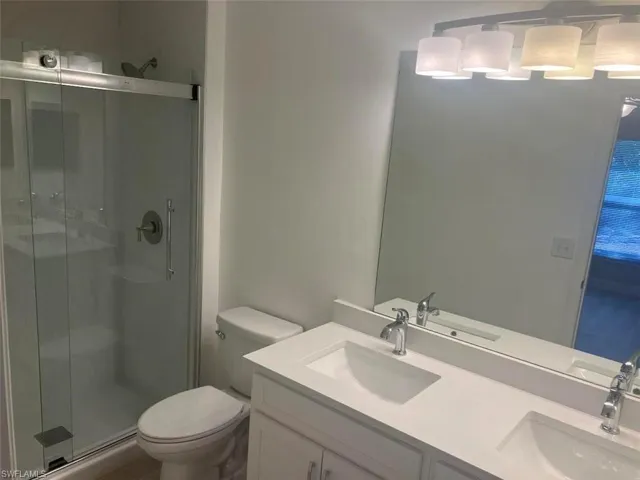 Bathroom featuring double vanity and a stall shower