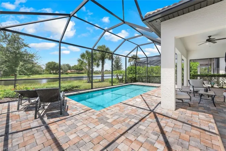 View of pool featuring a lanai, a water view, a patio, and ceiling fan