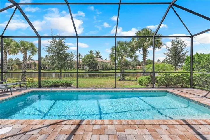 View of pool featuring a water view and glass enclosure