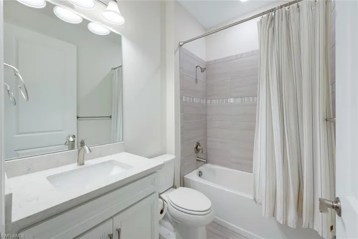 Full bathroom featuring vanity, toilet, and shower / tub combo with curtain