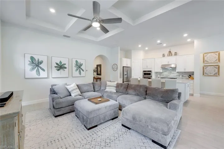 Living room with coffered ceiling, beamed ceiling, and ceiling fan
