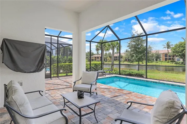 View of pool with a lanai, a patio, and a water view