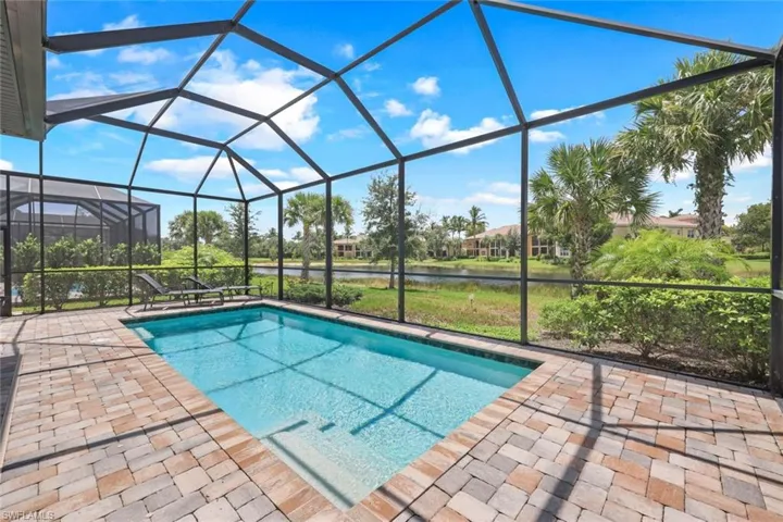 View of swimming pool featuring a lanai, a patio area, and a water view