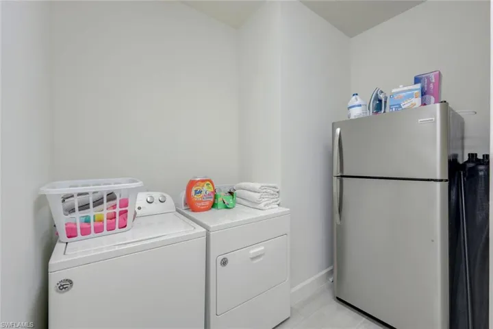 Washroom featuring separate washer and dryer and light tile patterned floors