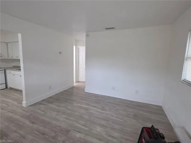 Unfurnished living room with light wood finished floors and baseboards