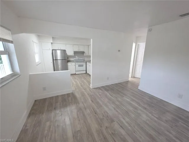 Unfurnished living room featuring baseboards and light wood-style floors