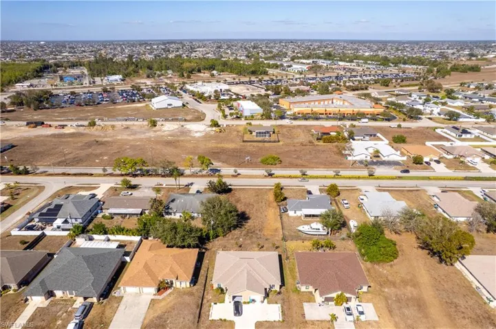Aerial view of property and surrounding area with nearby suburban area
