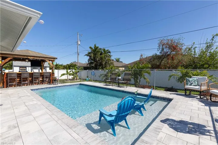 View of swimming pool with a gazebo, a bar, and a patio area