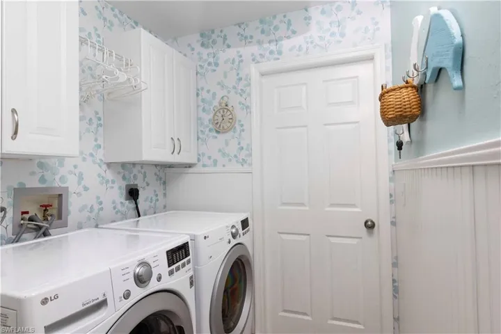 Laundry room featuring cabinets and washing machine and clothes dryer