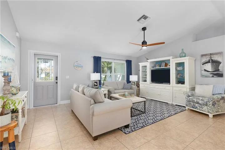 Tiled living room with vaulted ceiling and ceiling fan