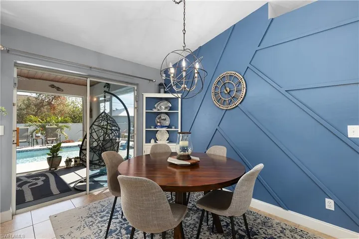 Tiled dining room featuring an inviting chandelier
