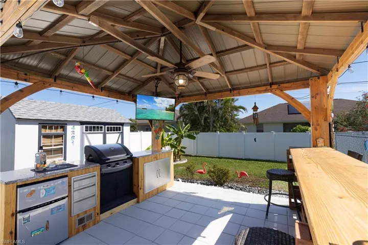 View of patio featuring area for grilling, an outdoor kitchen, a gazebo, and ceiling fan