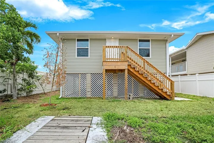 Rear view of property featuring stairs