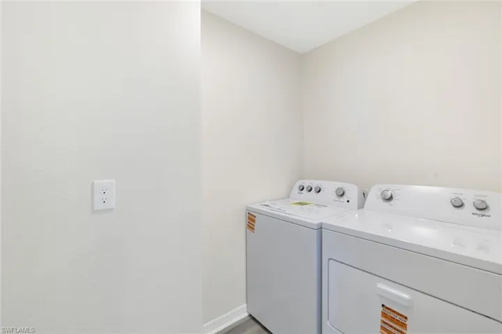 Laundry area featuring washer and clothes dryer and baseboards
