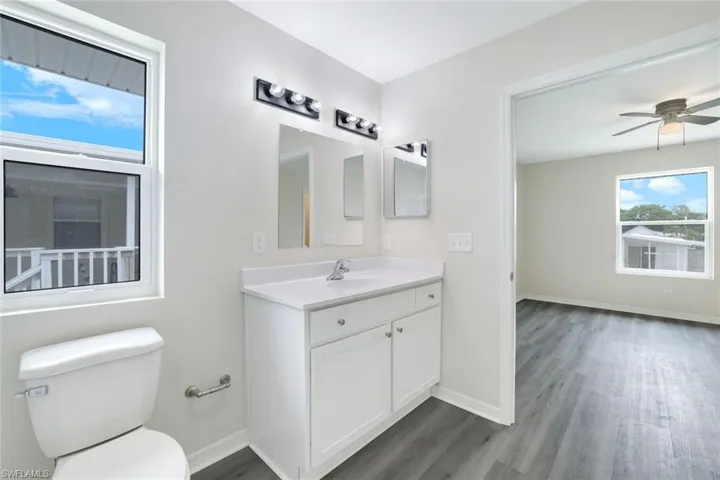 Bathroom featuring wood finished floors, vanity, and ceiling fan