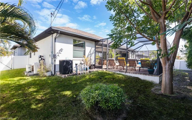Rear view of property with a fenced backyard, a sunroom, a patio, stucco siding, and glass enclosure
